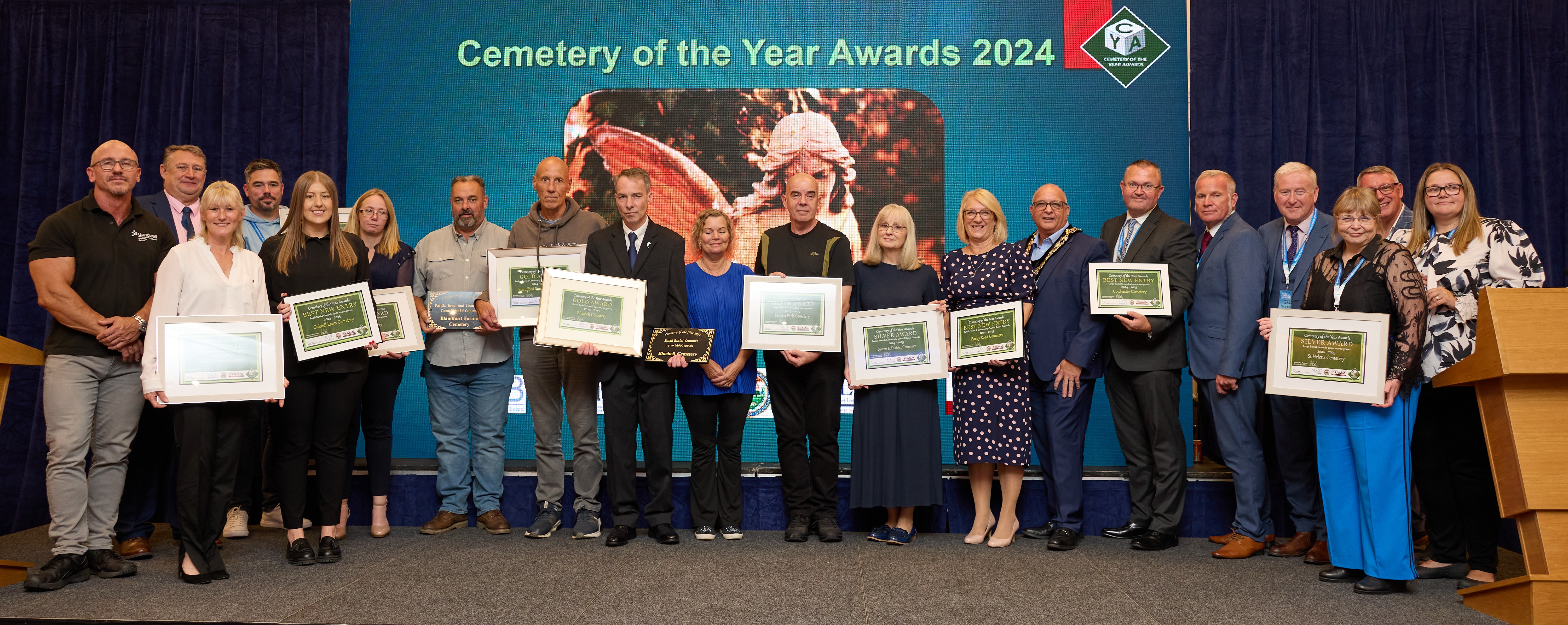 People standing on a stage holding certificates