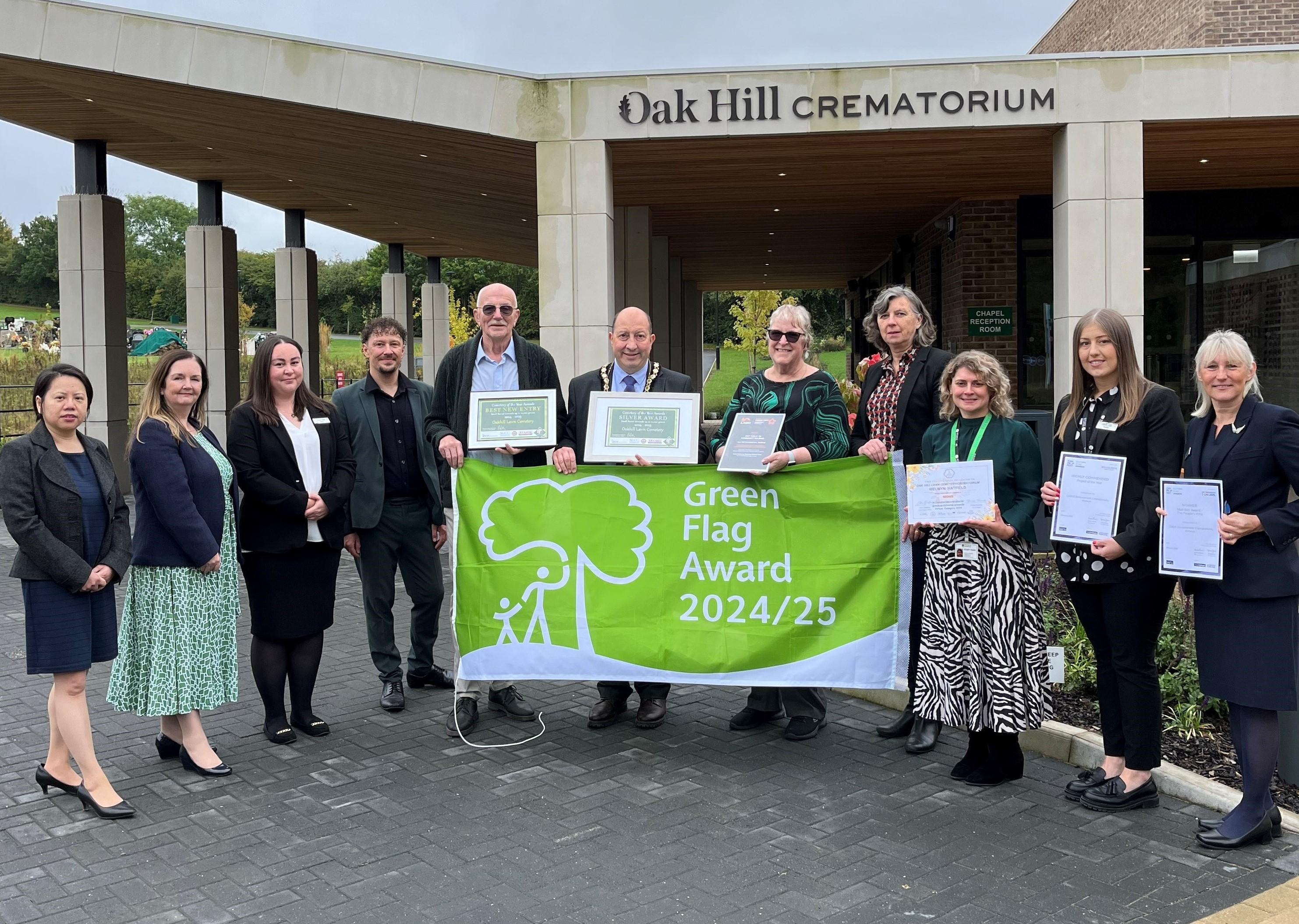 Chief Executive, Senior Managers, Councillors and Officers standing outside the reception holding awards.