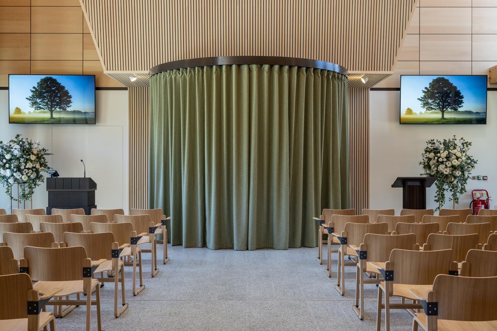 Inside of the chapel, where there are chairs and curtains blocking the coffin